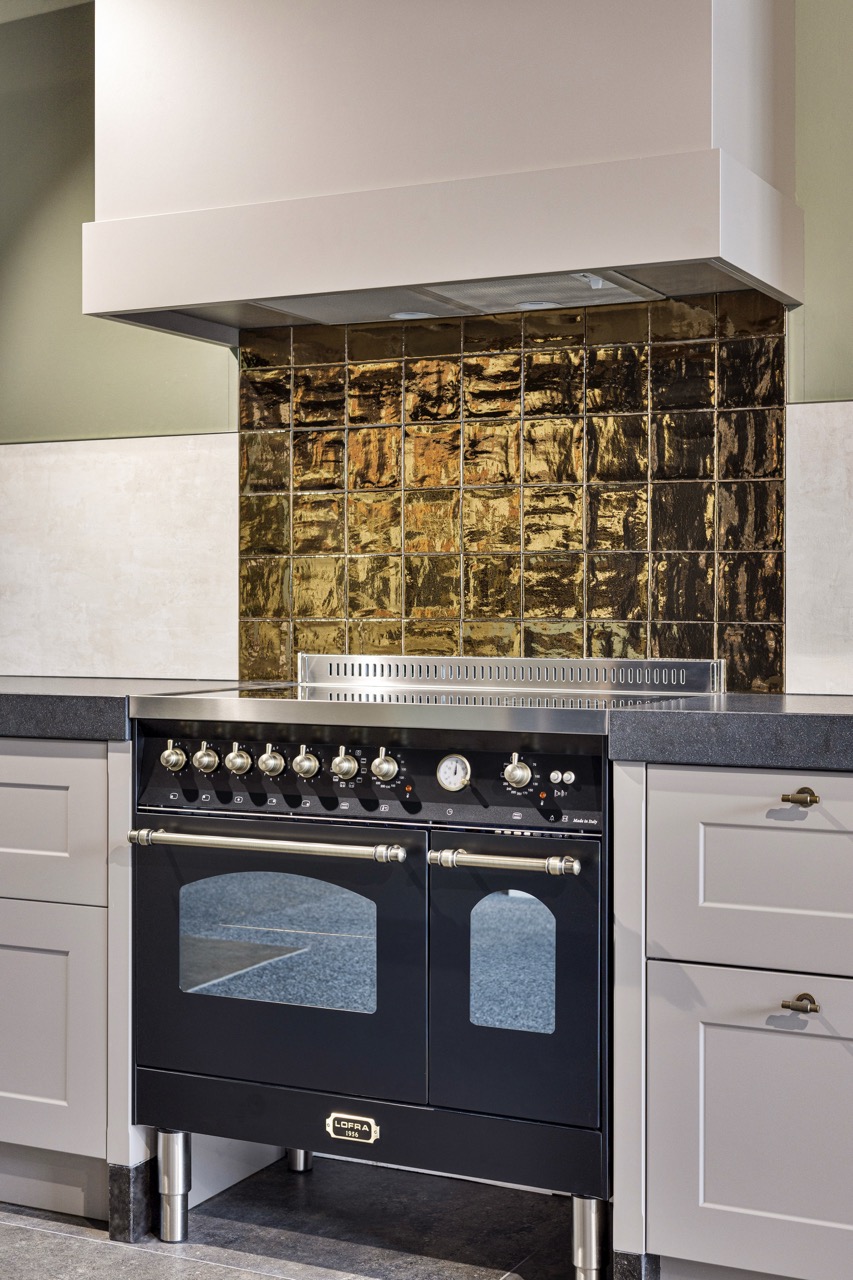 Landelijke keuken met zwart fornuis en gouden wandtegels - Showroom Borculo Marboma