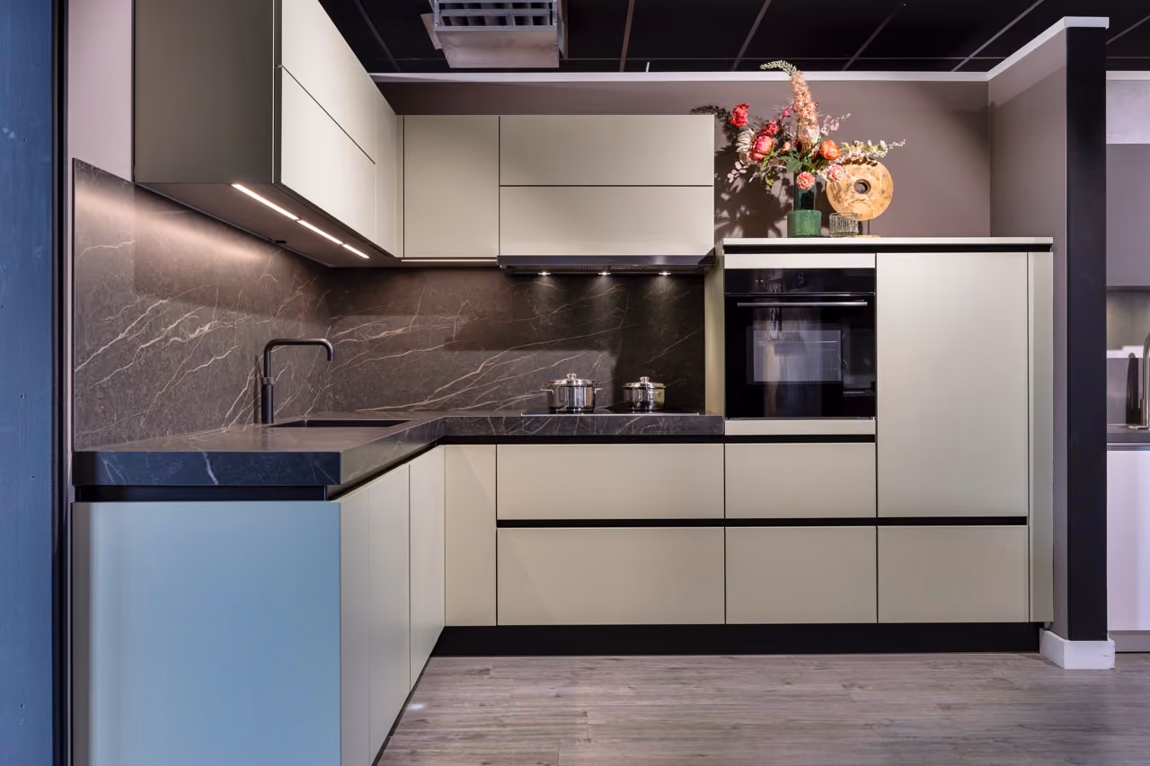 Moderne hoekkeuken in saliegroen met donker marmerlook werkblad - Showroom Borculo Marboma