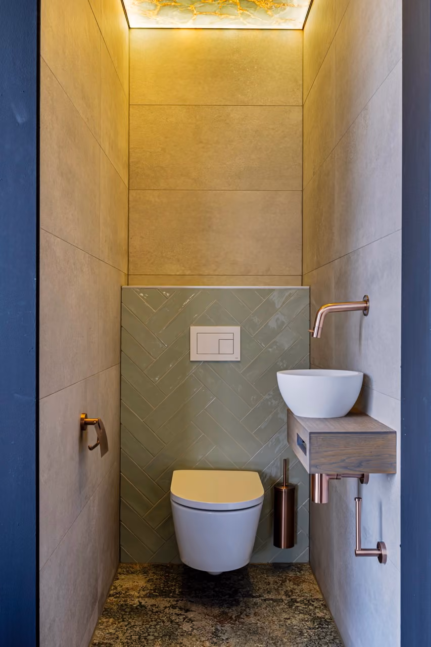 Toilet met groene visgraattegels en koperen kraan - Showroom Borculo Marboma