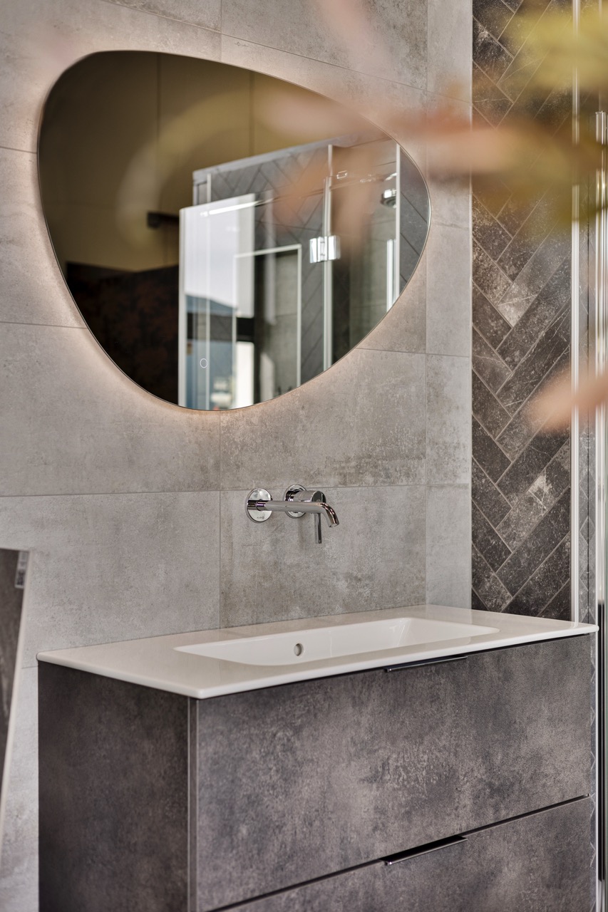 Grijs badmeubel in betonlook met visgraattegels en spiegel - Showroom Borculo Marboma