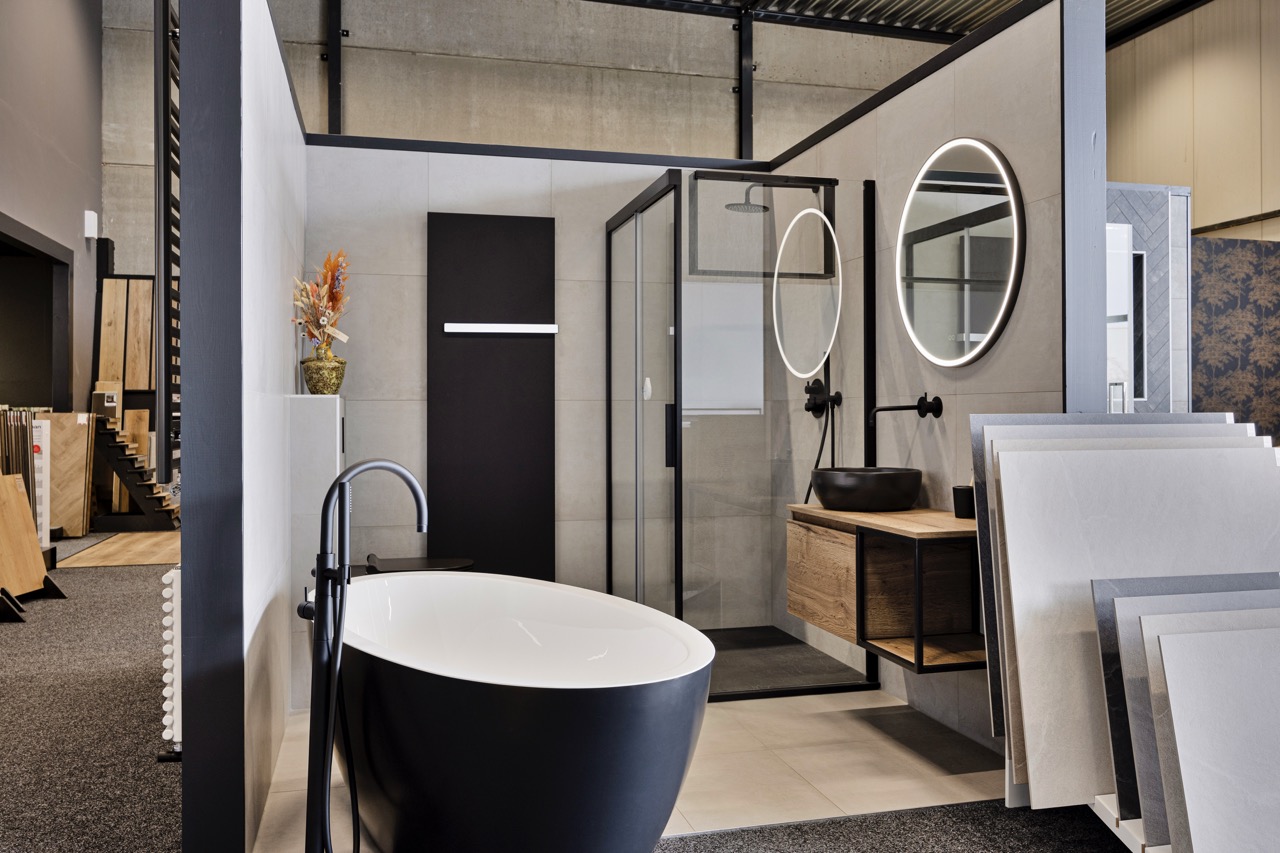 Badkamer met zwart vrijstaand bad, douche en houten badmeubel - Showroom Borculo Marboma