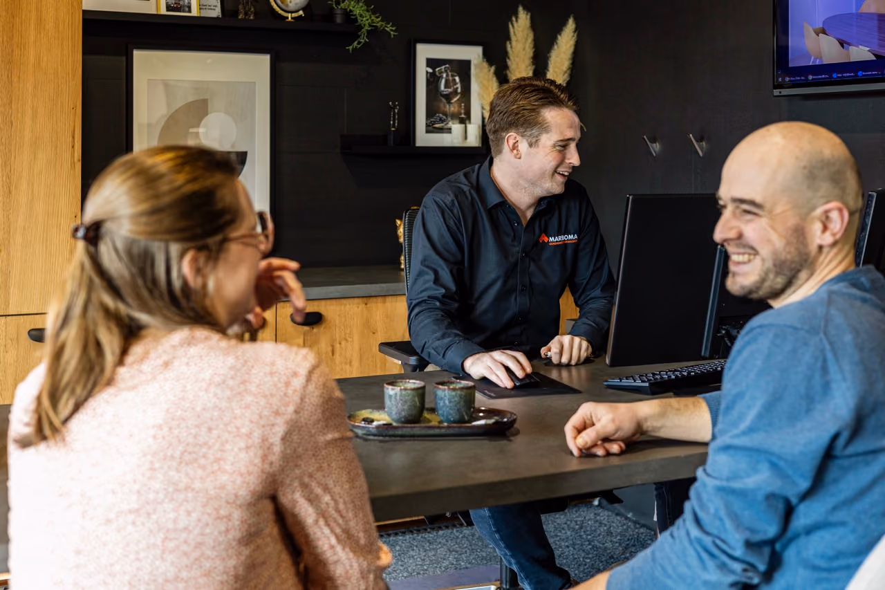 Adviseur en klanten lachen samen tijdens adviesgesprek - Showroom Borculo Marboma