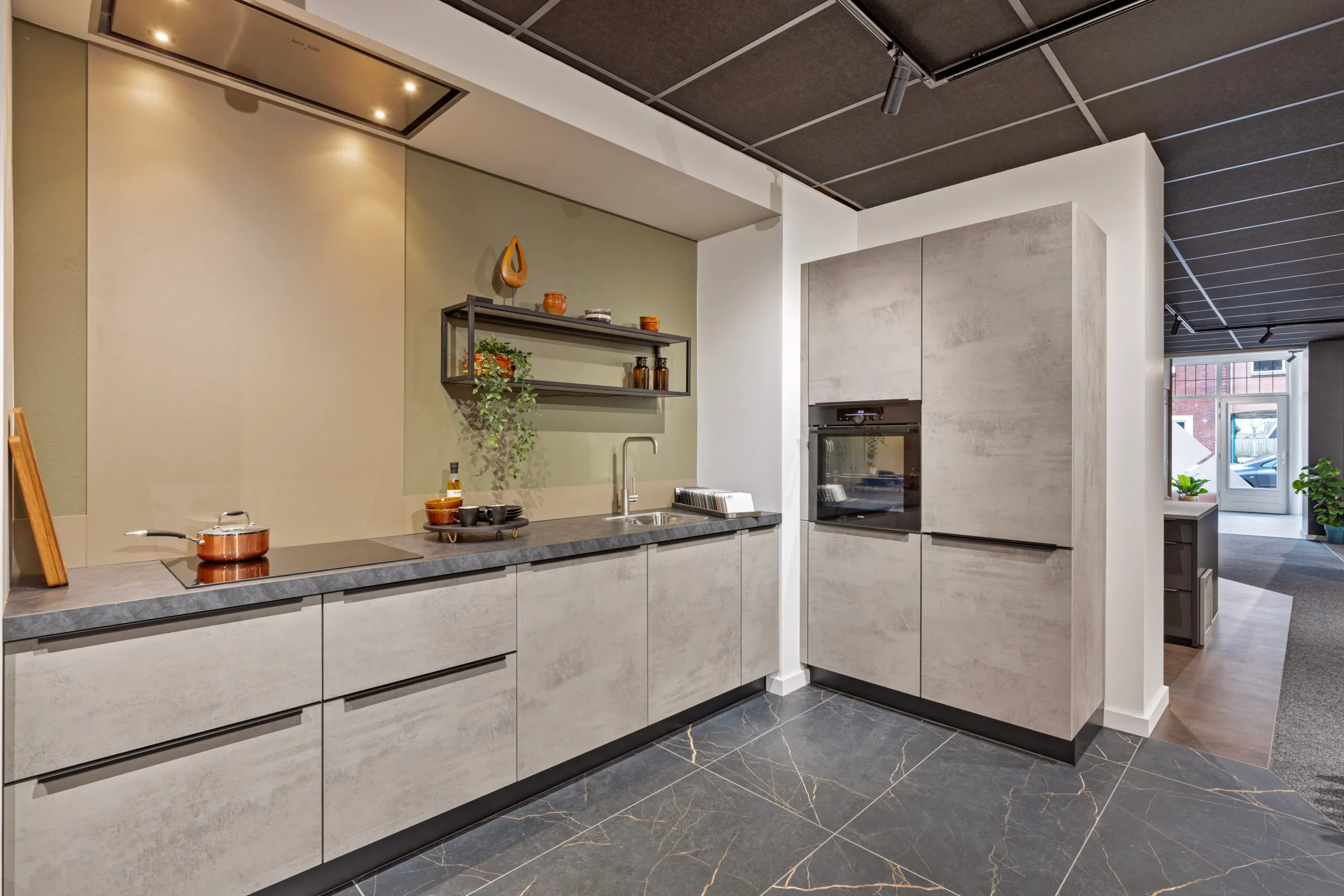 Moderne keuken in betonlook met donker werkblad en tegelvloer - Showroom Goor Marboma