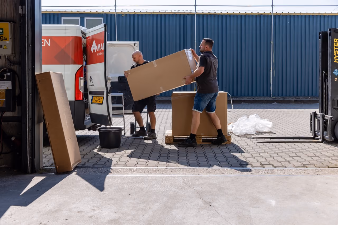 Medewerkers van Marboma laden keukenonderdelen uit bij het magazijn