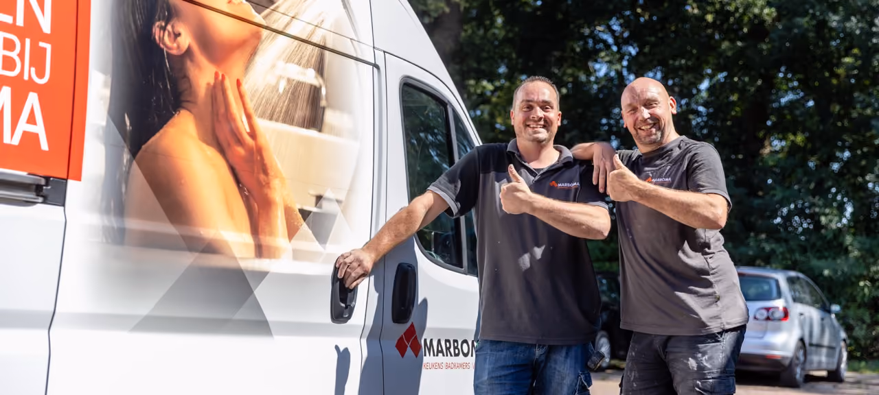 Twee vakmensen van Marboma steken hun duim op bij de bedrijfsbus