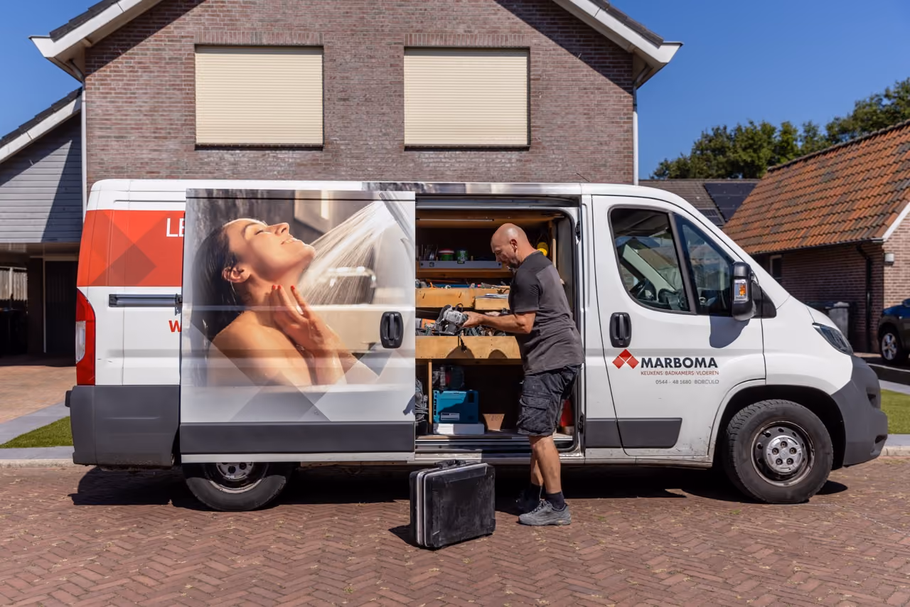 Vakman van Marboma haalt materiaal uit de bedrijfsbus voor een woning