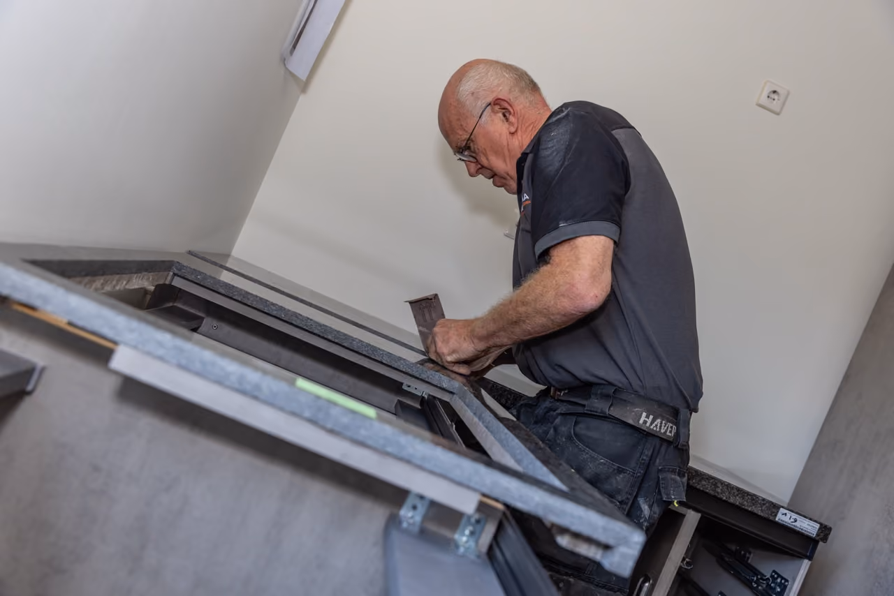 Keukenmonteur van Marboma stelt een keukenkast af tijdens de montage van een nieuwe keuken