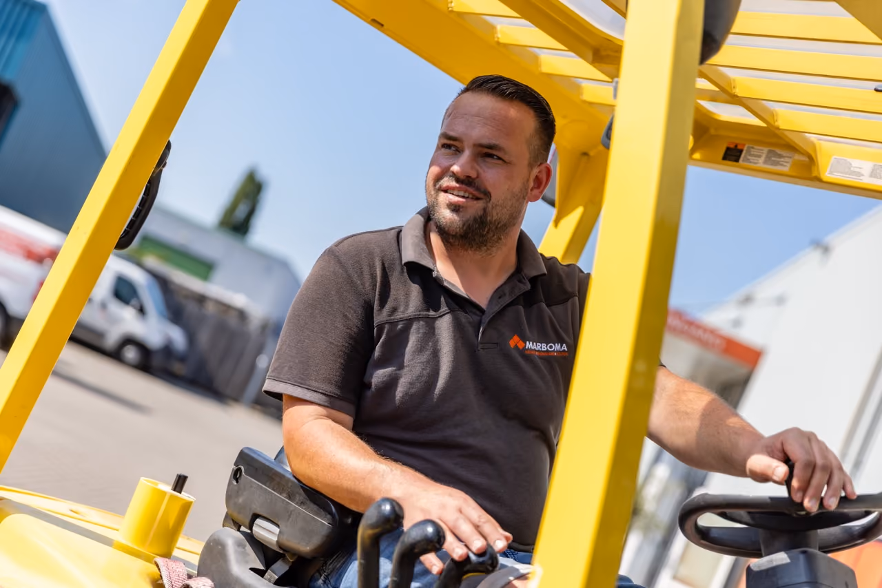 Medewerker van Marboma rijdt op de heftruck bij het magazijn