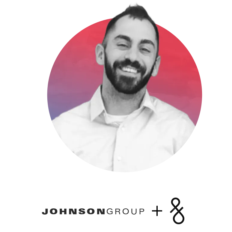 Smiling man with beard wearing a white shirt in front of a red and purple circular background.