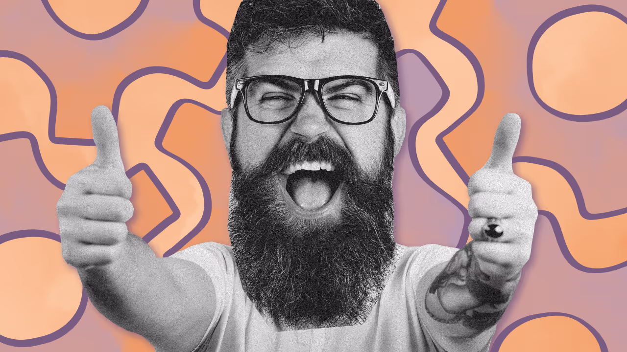 Bearded man with glasses showing two thumbs up and smiling widely against an abstract orange and purple wavy background.