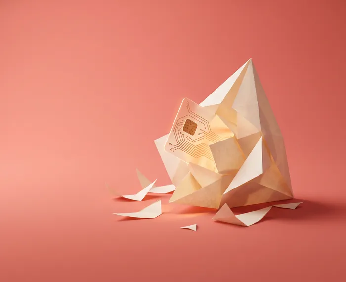Pembe arka planda, açılan origami kağıt yapısının içinden çıkan şeffaf akıllı kart; üretken yapay zekâ ile prototip oluşturma görseli.