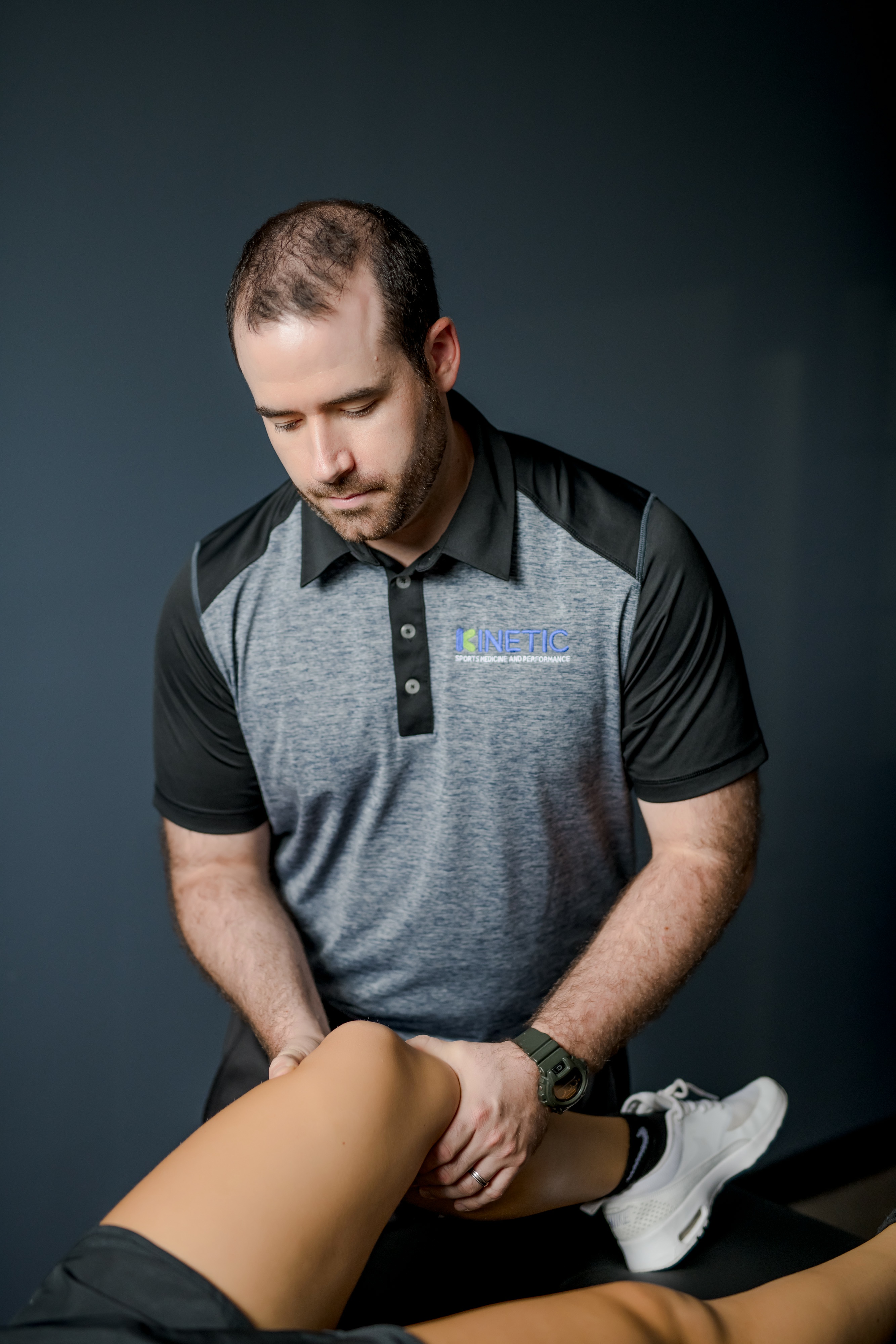 Patient working with a provider at a sports physical therapy clinic in Delafield, WI during a manual therapy session for injury rehabilitation