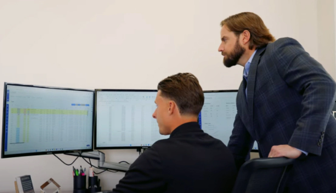 two men looking at a computer