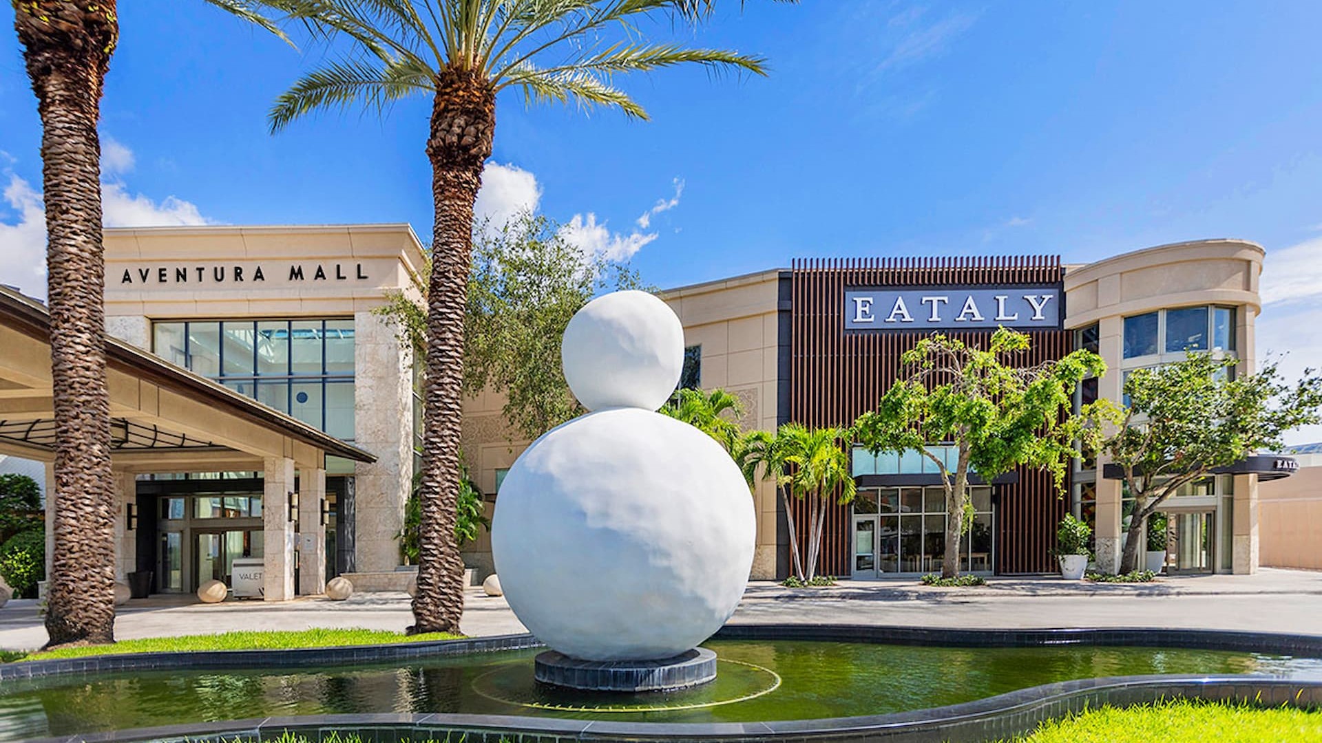 The exterior entrance to Aventura Mall in Florida, featuring a large art sculpture