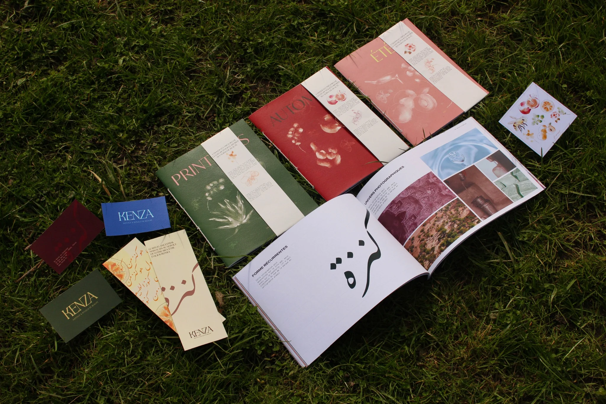 Livre vert foncé intitulé 'PRINTEMPS' avec illustrations botaniques, posé sur un fauteuil en velours beige.