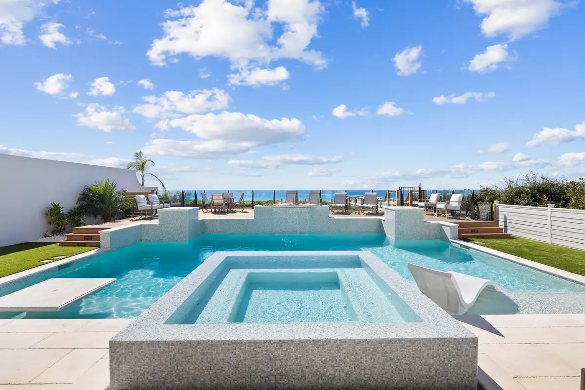 Clear pool and raised tiled spa with a Gulf view at a home along Scenic Highway 30A