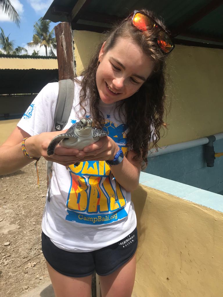 Camp participant holds a turtle at Serangan Turtle Conservation.