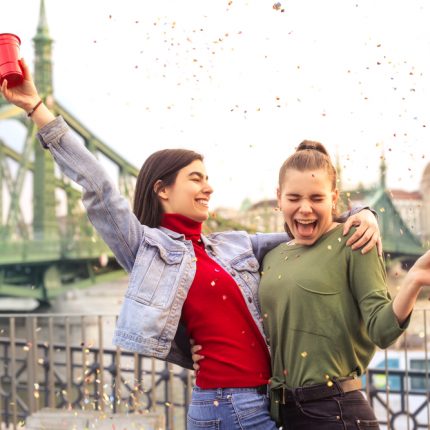 Two camp participants laugh in front of a European bridge.