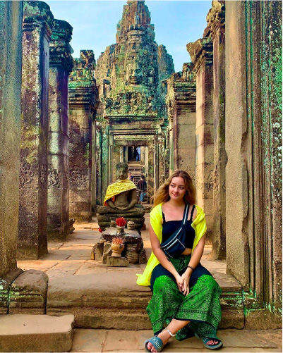 Camp participant sits in front of a Vietnamese temple.