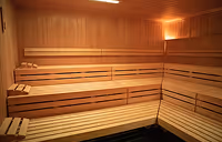 Interior of a wooden sauna room with tiered benches along the walls.