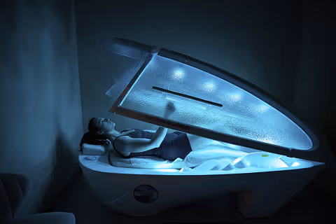 Close-up of a person's bare back with water droplets on the skin. Showing the effectiveness of Light Therapy to moisture the skin.