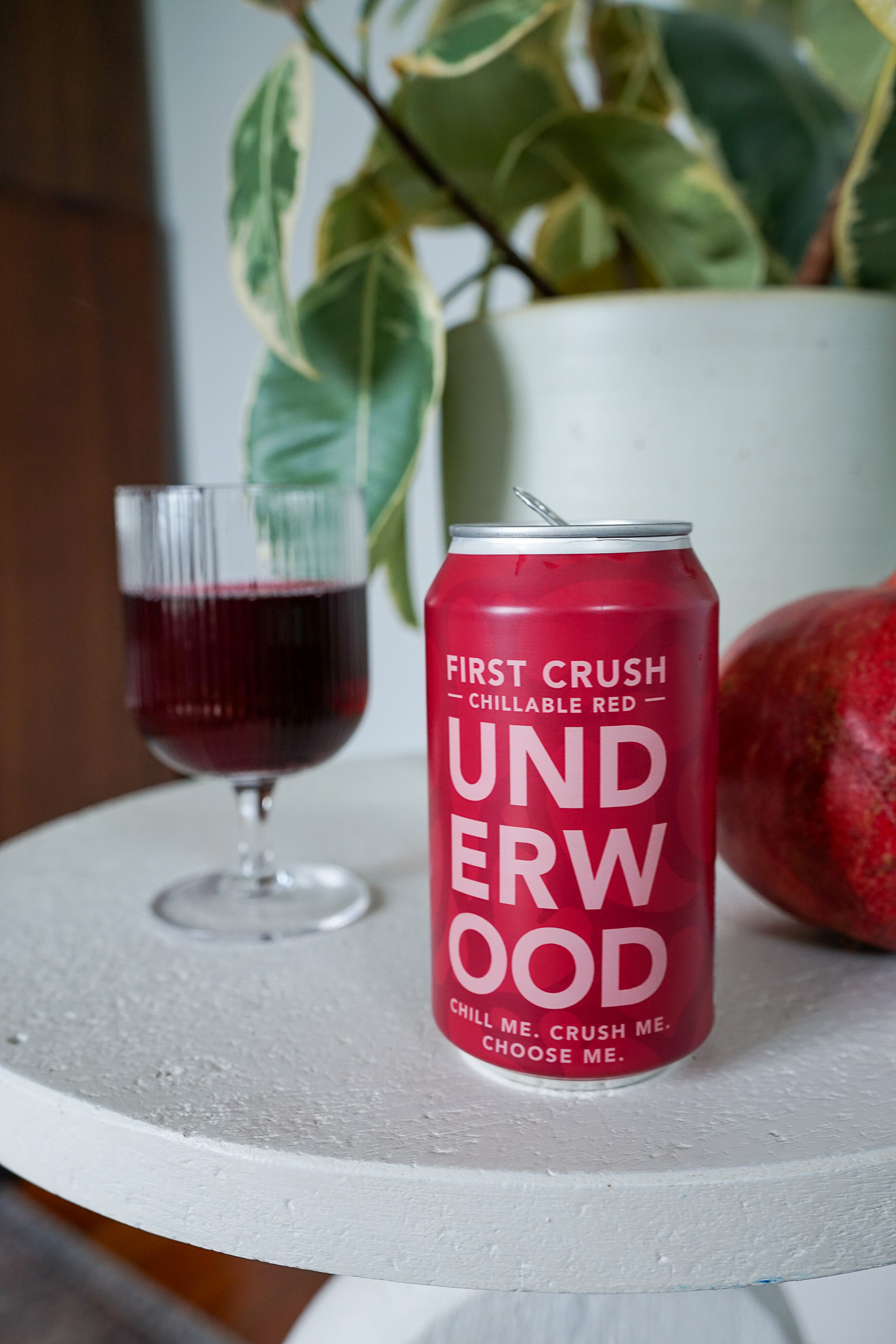 Hand with pink nail polish pouring Underwood Rosé Bubbles non-alcoholic drink from a pink can into a clear glass.