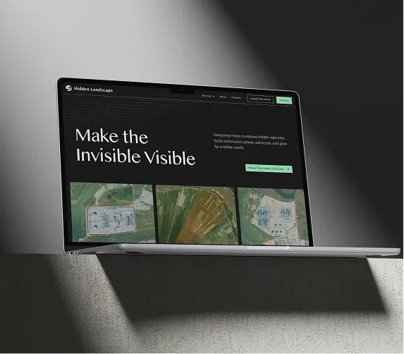 Laptop screen showing Hidden Landscape site with text 'Make the Invisible Visible' and aerial landscape maps.