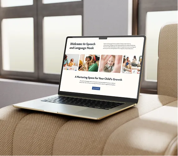 Laptop on beige couch displaying a website for Speech and Language Nook with child-related images.