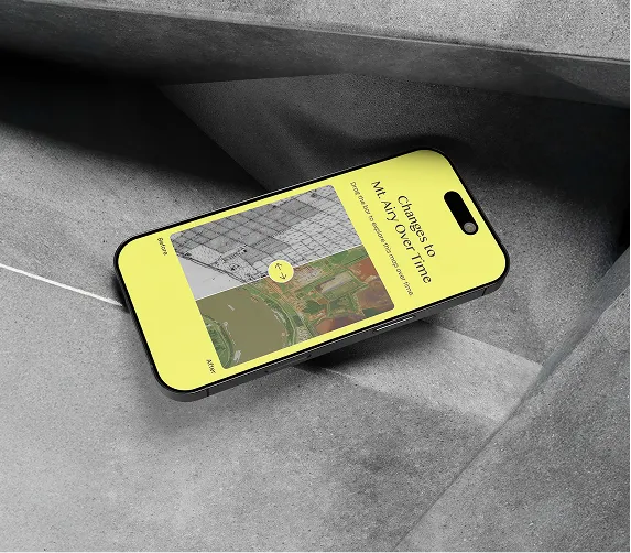 Smartphone on gray concrete showing a yellow screen with a graph and text about changes over time.