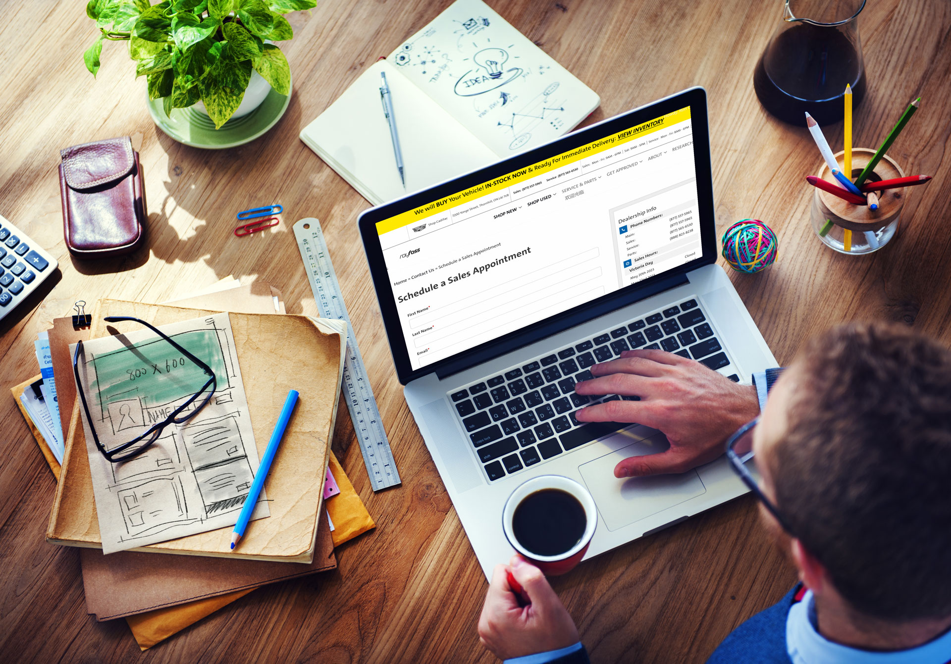 Person holding a cup of coffee and scheduling a sales appointment on a laptop at a wooden desk with office supplies.