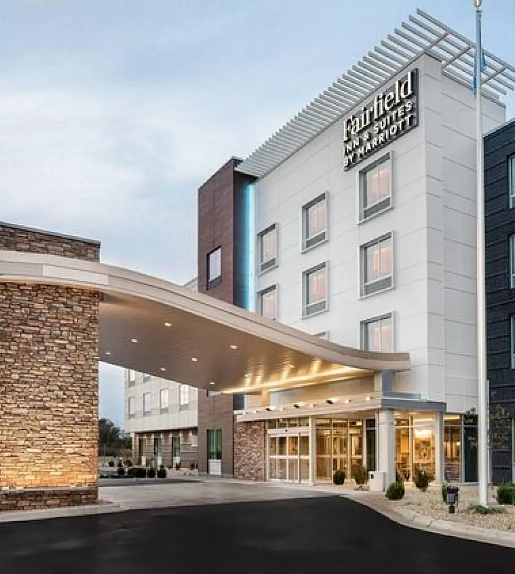Exterior view of a Fairfield Inn & Suites by Marriott hotel entrance with a covered drop-off area.