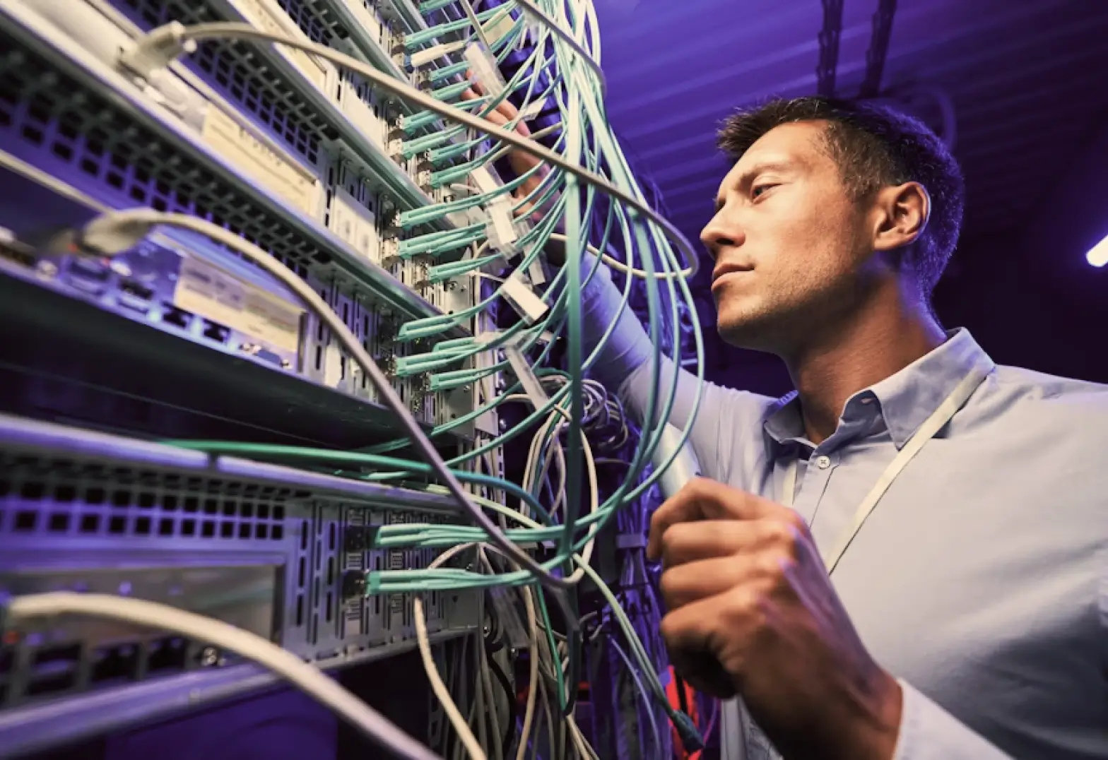 IT professional connects and manages network cables in a server room.