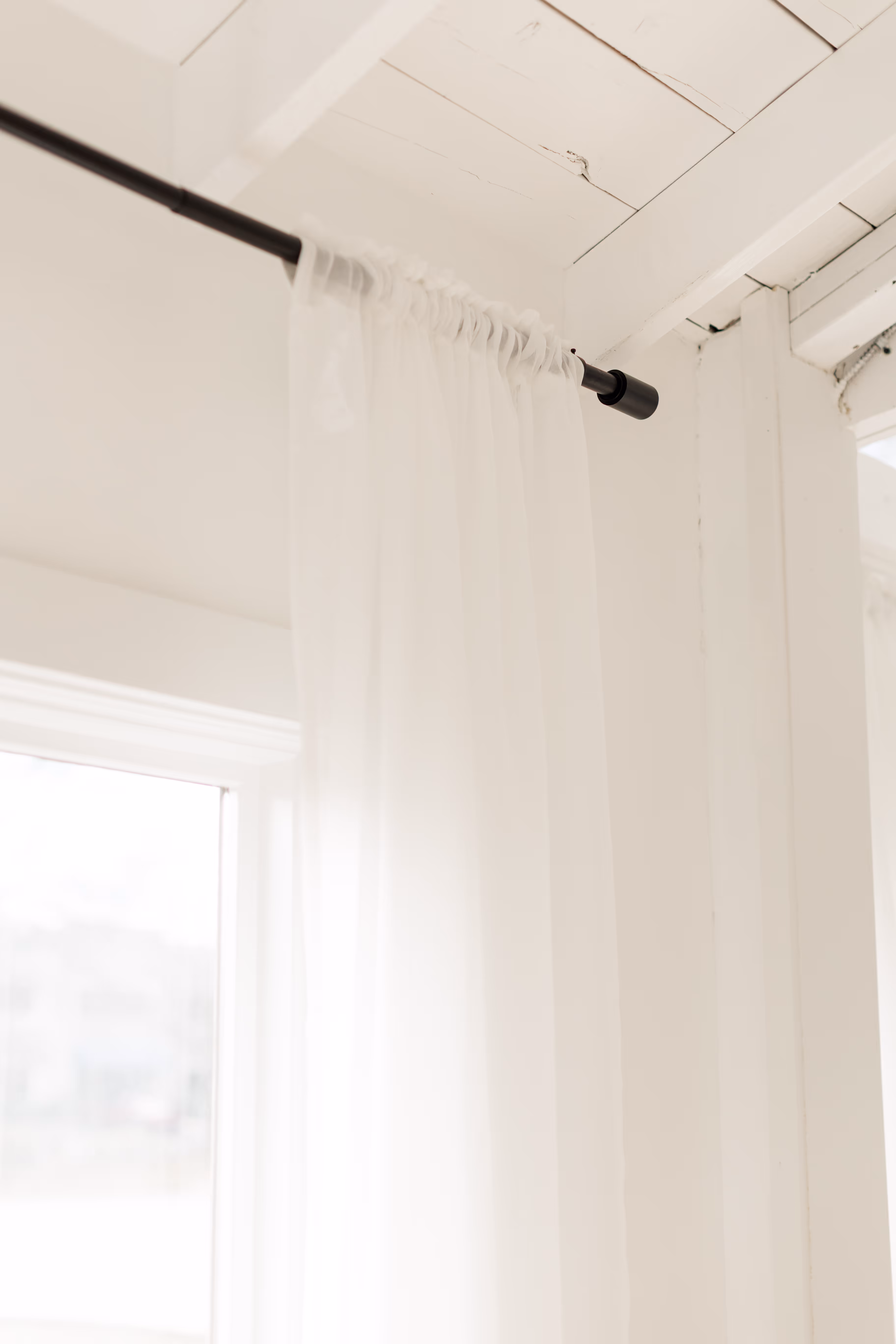 Natural light shining through window and hitting white curtains