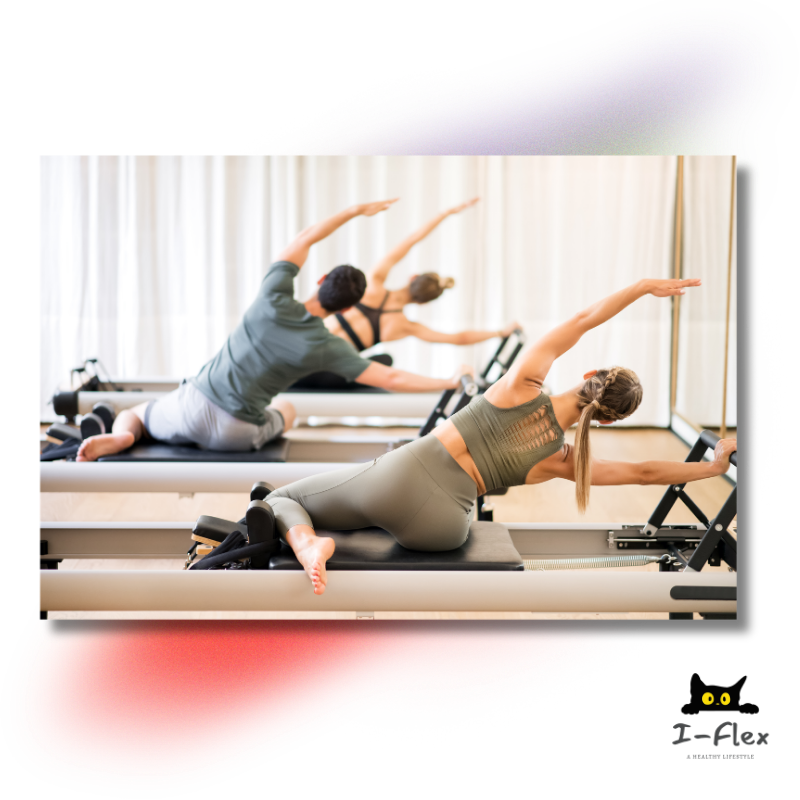 Three people exercising on Pilates reformer machines stretching sideways in a bright studio.