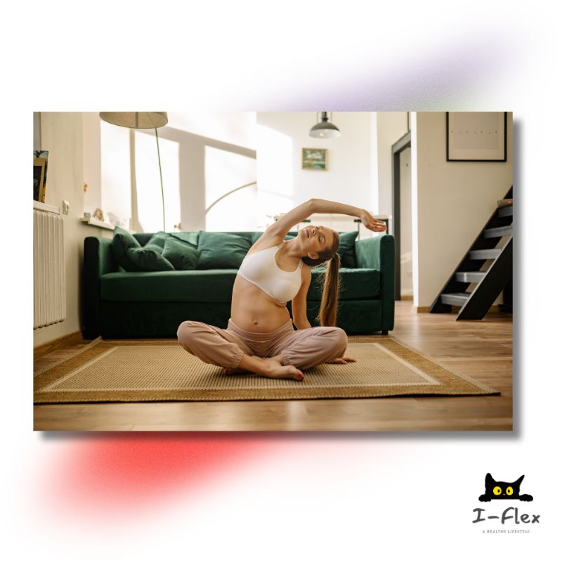 Pregnant woman in sportswear stretching with crossed legs on a rug in a sunlit living room.