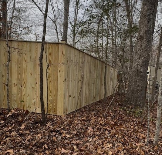 New wood privacy fence installed along a wooded property line at a home in Arlington, VA