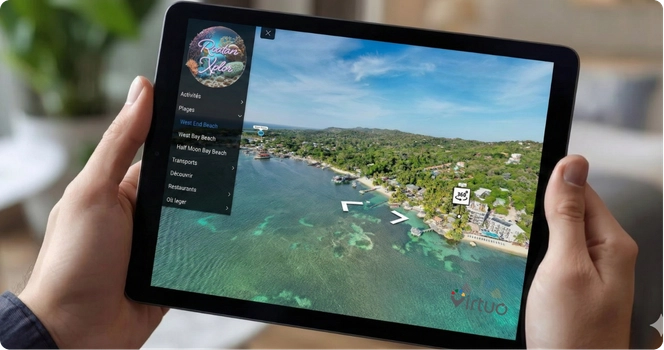 Aerial view of a tropical beachfront resort with turquoise waters, coral reefs, and lush greenery under a blue sky.