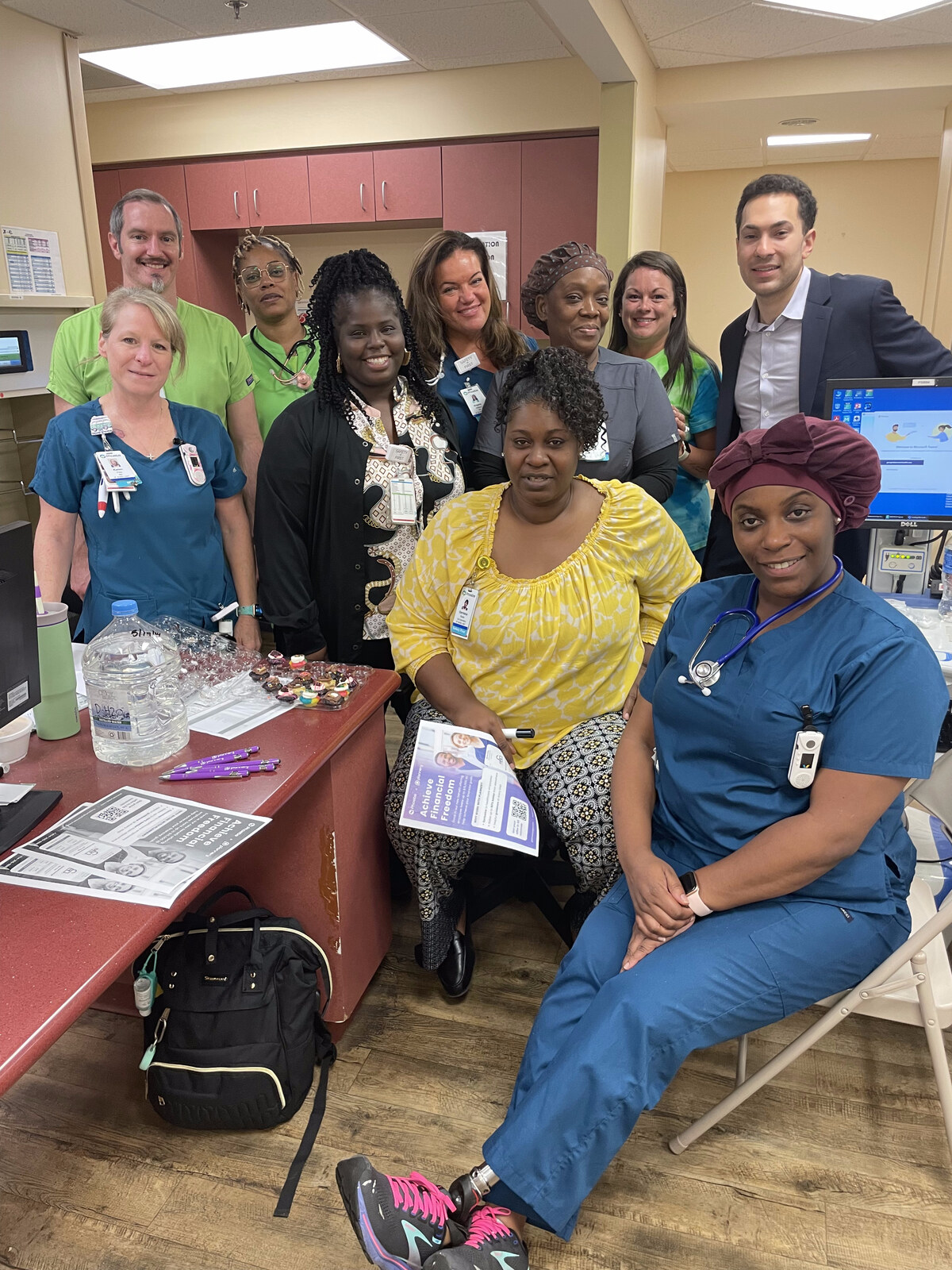 Phoebe Putney Health System employees gathered at a Plannery benefits enrollment event: nurses, clinical staff, and administrators in scrubs and business attire.