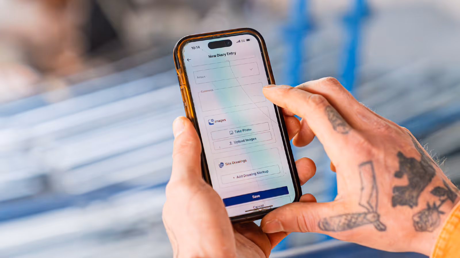 Construction worker entering a site diary update on a mobile phone