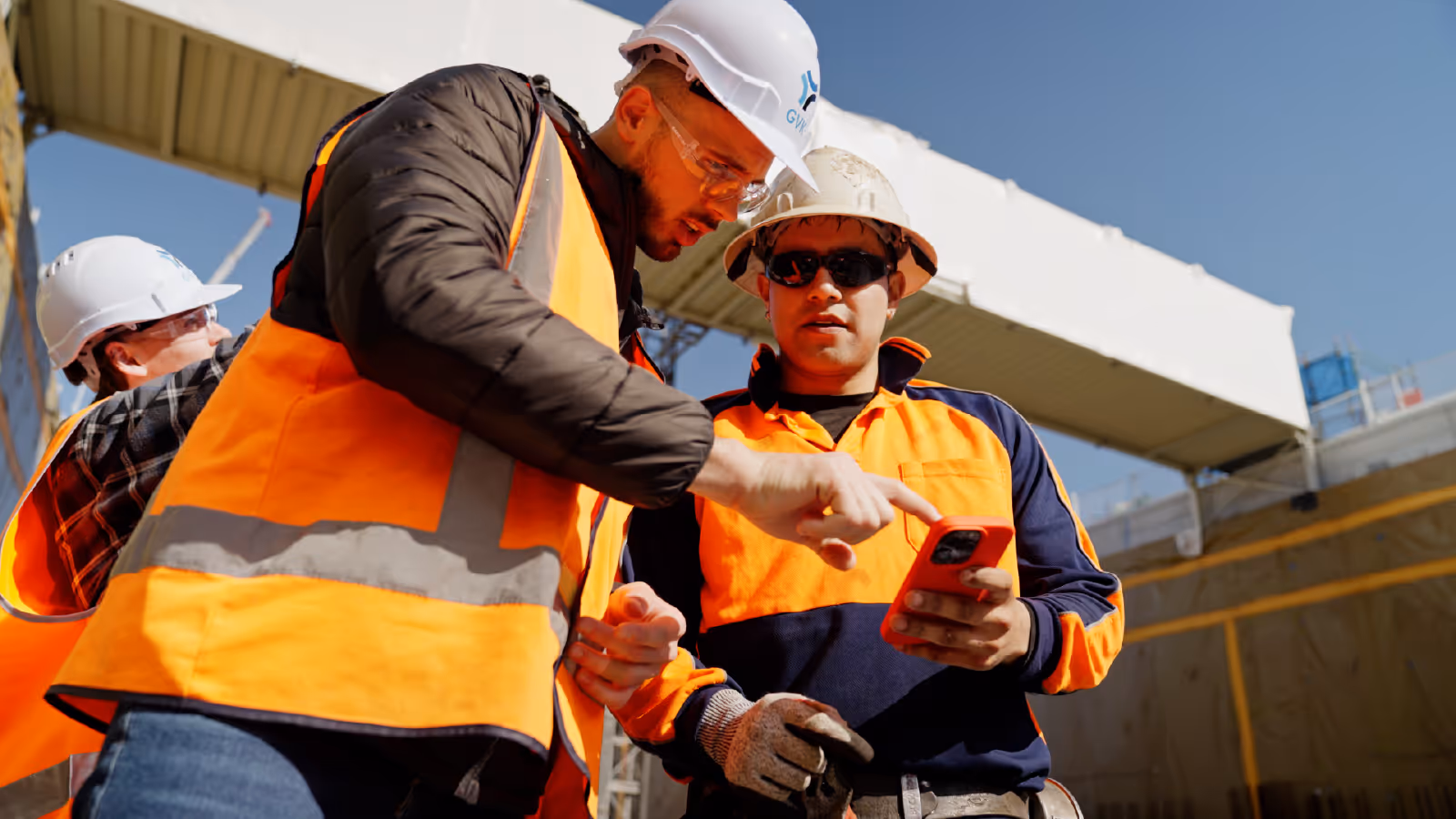 Construction workers reviewing project details together on a smartphone