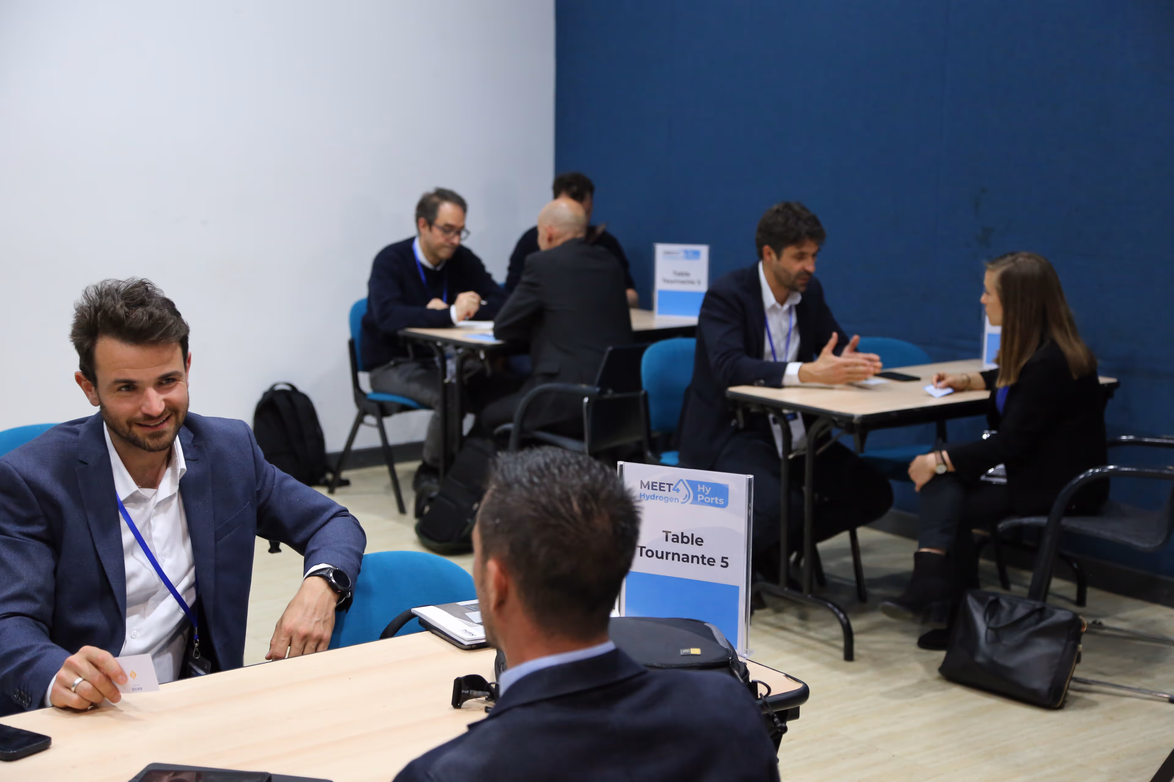 Professionnels en réunion à des tables tournantes lors d'un événement de réseautage HyPorts.