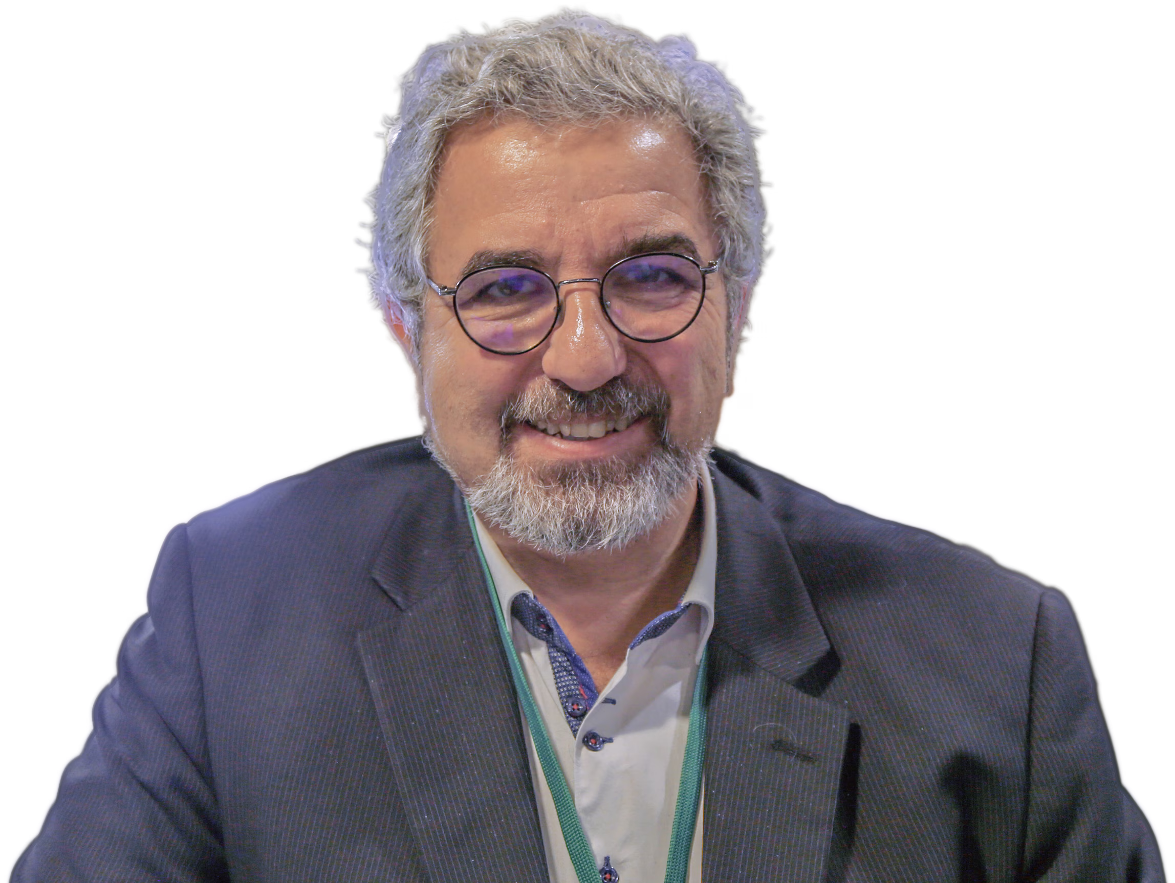 Homme souriant aux cheveux gris et barbe, portant des lunettes rondes et un costume bleu foncé.