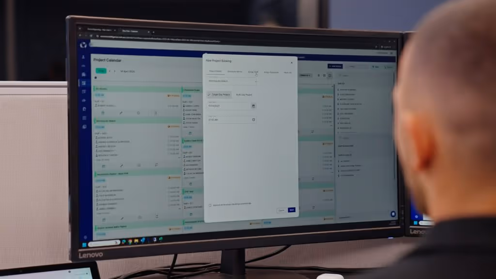 Man in the office looking at a computer screen using Neo's project calendar