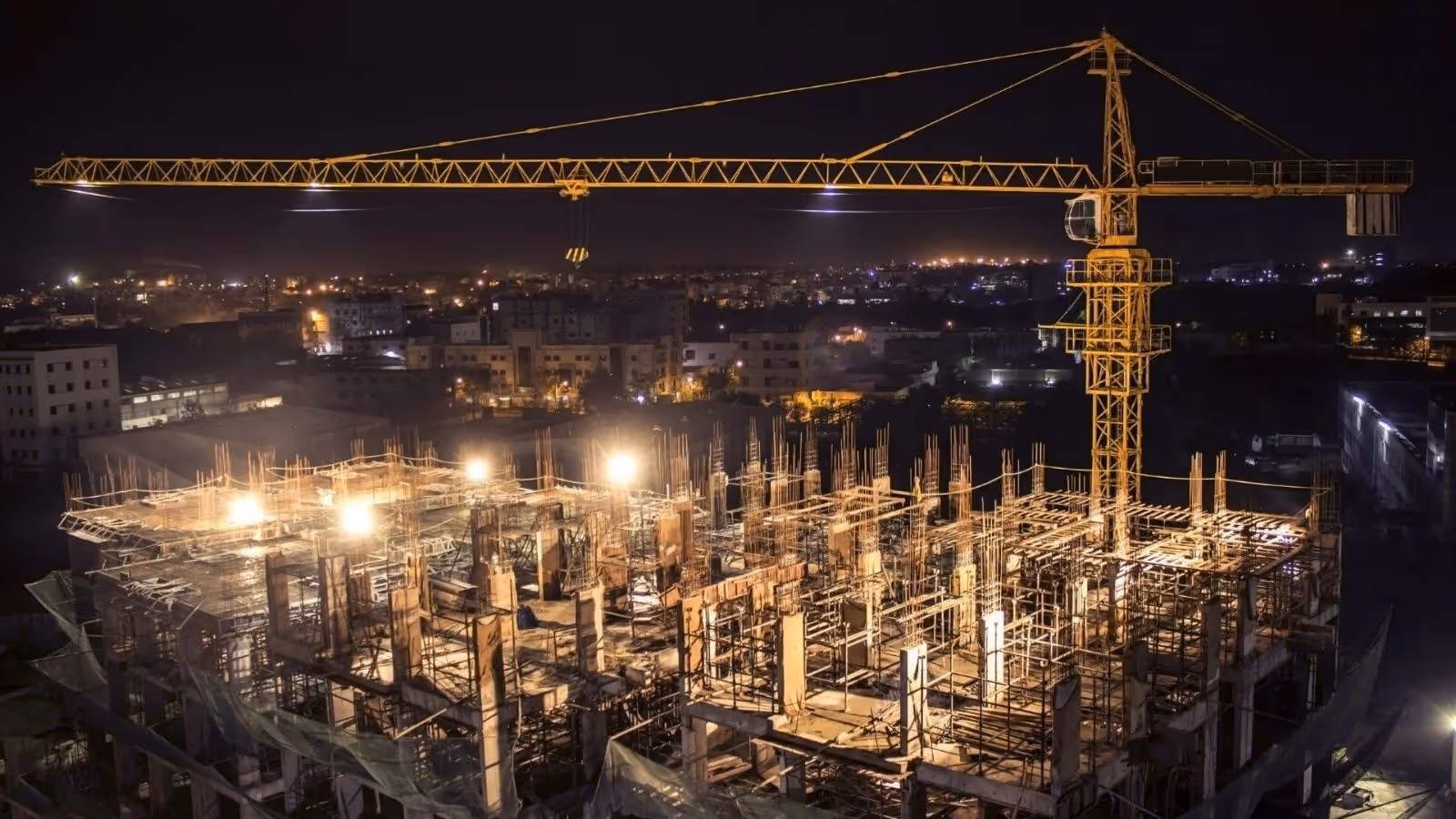Large construction site at nigh, well-lit by strong flood lights