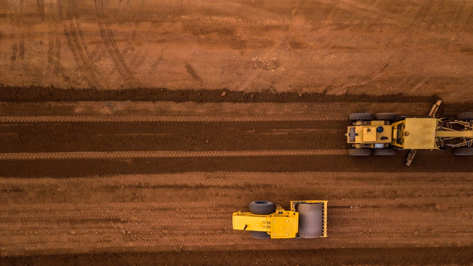 Birds eye view of civil construction site showing heavy equipment and red Australian soil