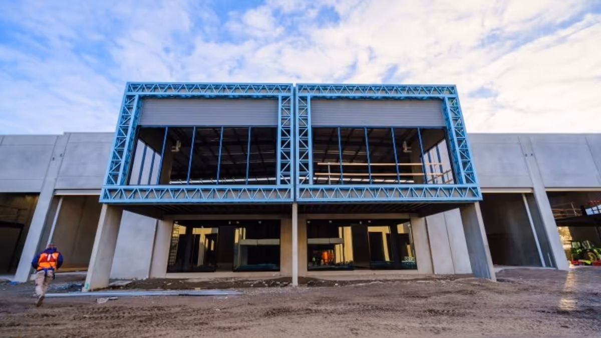 Front view of an industrial construction site and a worker walking past