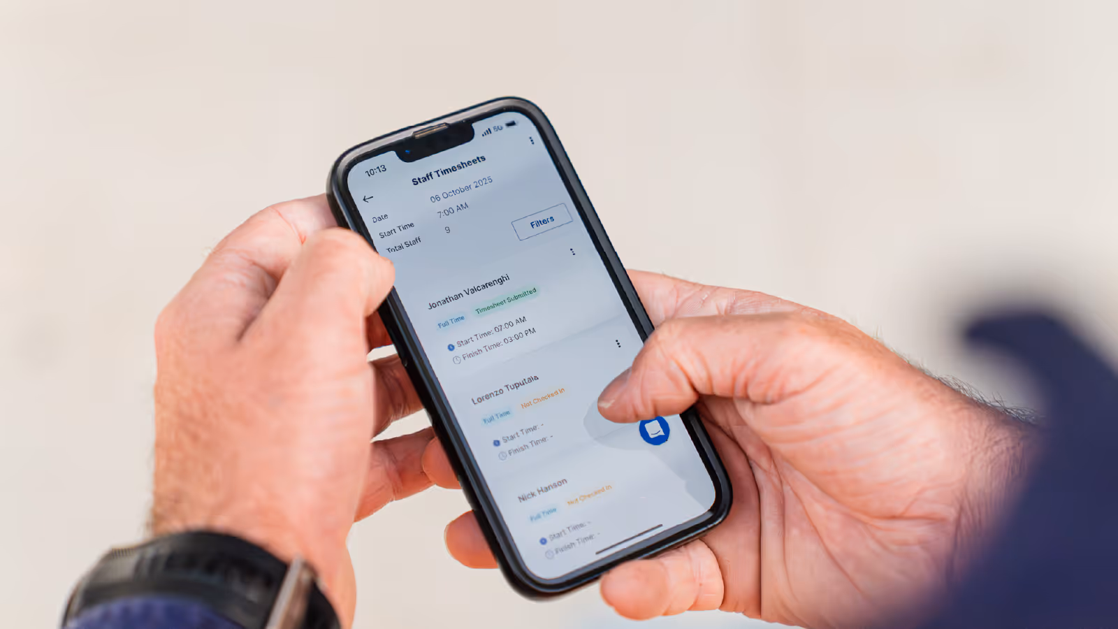 A phone in someone's hands, with the person looking at the Neo digital timesheets feature.