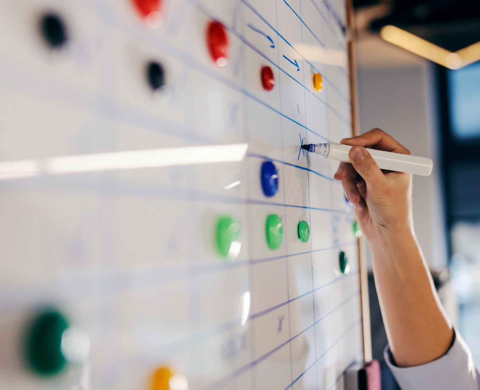 A person making changes to a timesheet/payroll structure on a whiteboard.