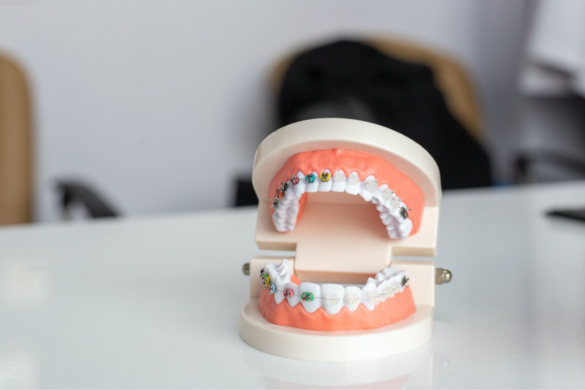 Dental model showing teeth with colorful braces on a white surface.
