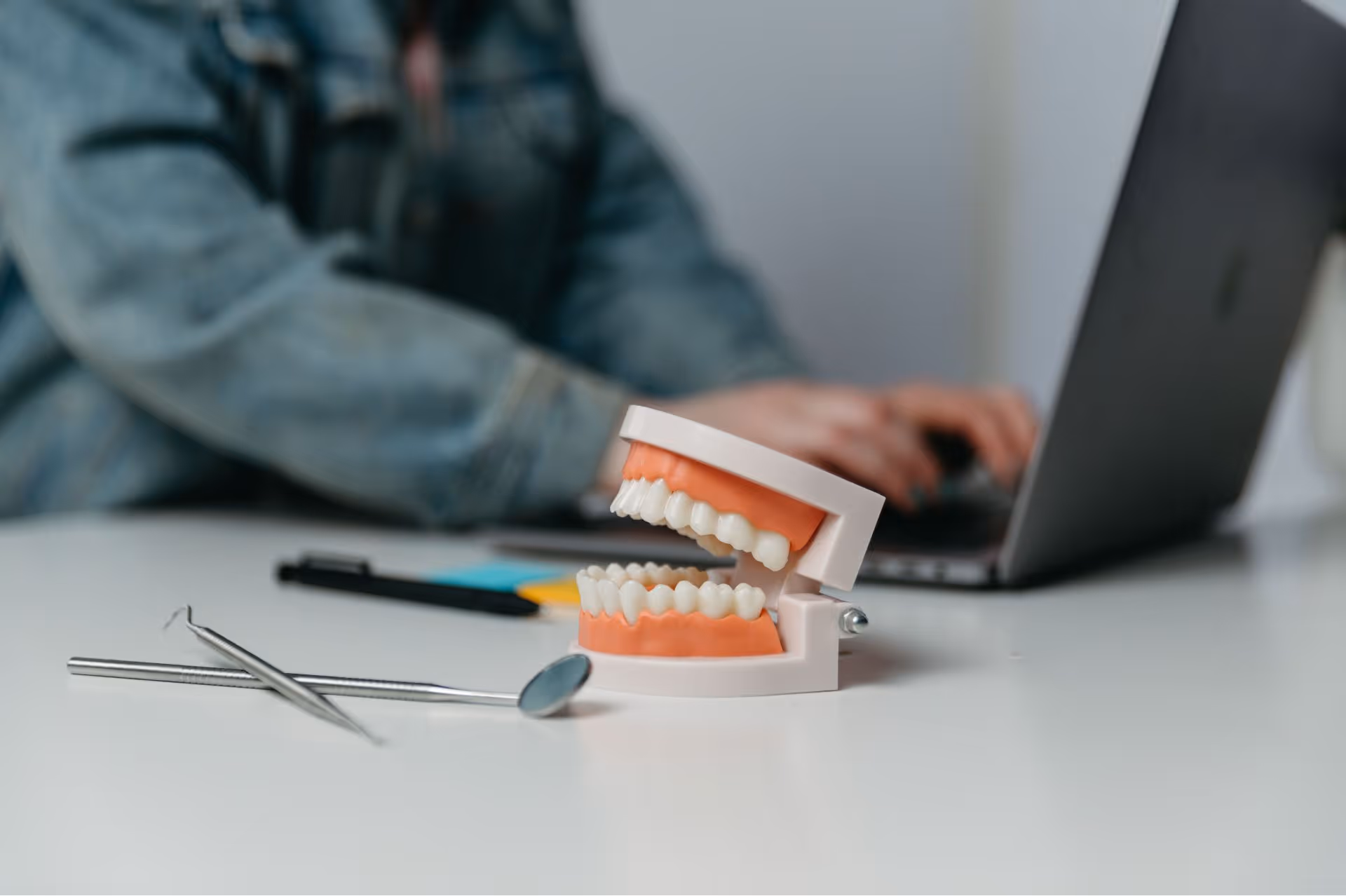 Dental model showing teeth with colorful braces on a white surface.